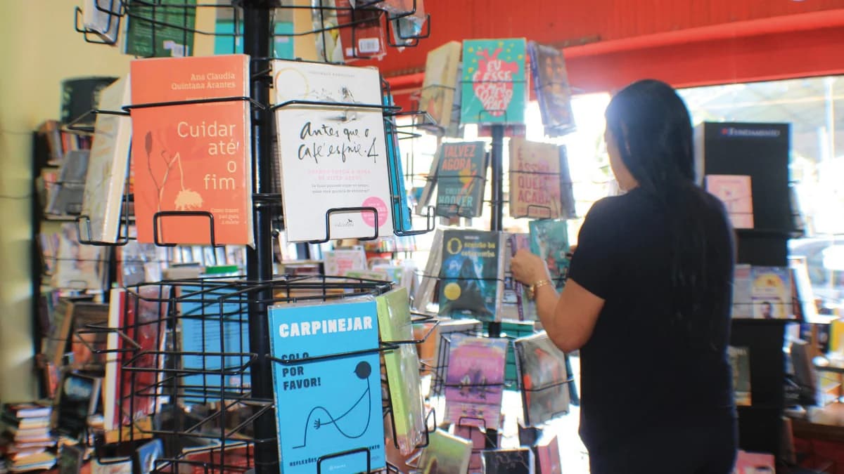 Estantes de livros em livraria brasileira com leitores ao fundo — cena do mercado editorial em expansão no Brasil em 2026