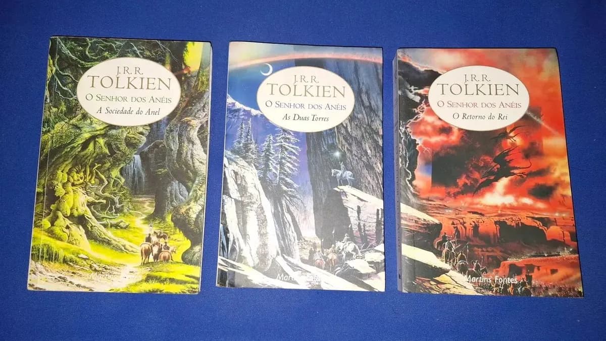 Coleção de livros infantis de J.R.R. Tolkien — Roverando, Ferreiro do Bosque Maior e Mestre Giles d'Aldeia sobre uma mesa de madeira